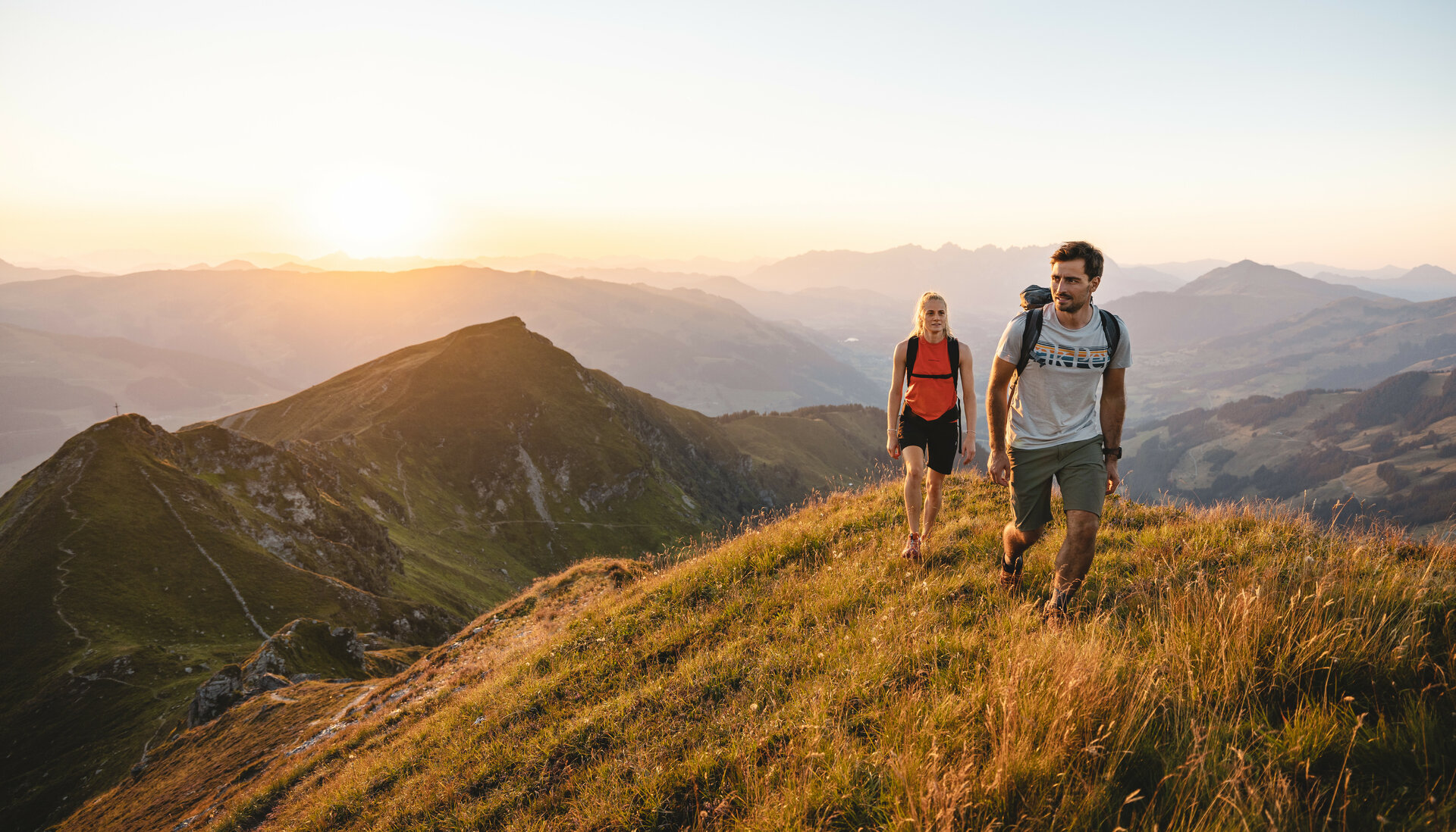 Zwei Menschen wandern bei Sonnenaufgang