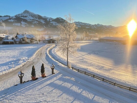 Verschneite Tallandschaft mit Blick auf das Kitzbüheler Horn bei Sonnenaufgang.