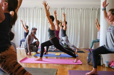 Yoga Eine Gruppe von Menschen übt Yoga in einem hellen Raum. Die Teilnehmer sind in verschiedenen Yoga-Posen und konzentrieren sich auf ihre Bewegungen.