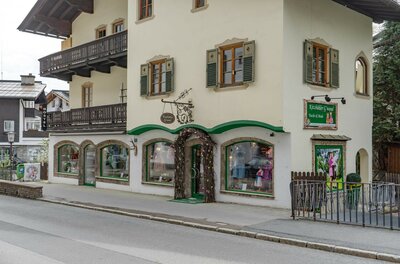 Traditionelles Gebäude mit Trachtengeschäft im Erdgeschoss und Holzbalkonen.