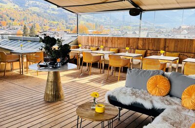 Eine moderne Terrasse mit gemütlichen Sitzgelegenheiten und einem schönen Ausblick auf die Landschaft. Die Einrichtung ist stilvoll und einladend, ideal für entspannte Stunden.