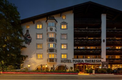 Hotel Maria Theresia Außenansicht Beleuchtete Außenansicht des Hotel Maria Theresia bei Dämmerung mit Erker und Holzbalkonen.