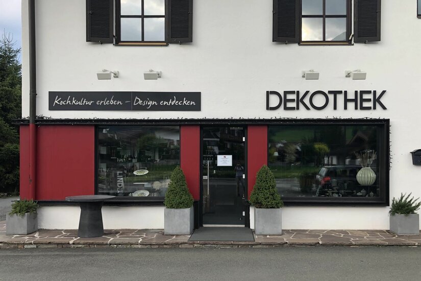 Außenansicht des Geschäfts Dekothek mit Schaufenstern und roter Fassade.