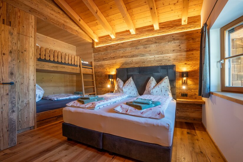 Schlafzimmer Apartment Taxer Modernes Schlafzimmer mit Doppelbett und Etagenbett aus Altholz.