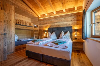 Schlafzimmer Apartment Taxer Modernes Schlafzimmer mit Doppelbett und Etagenbett aus Altholz.