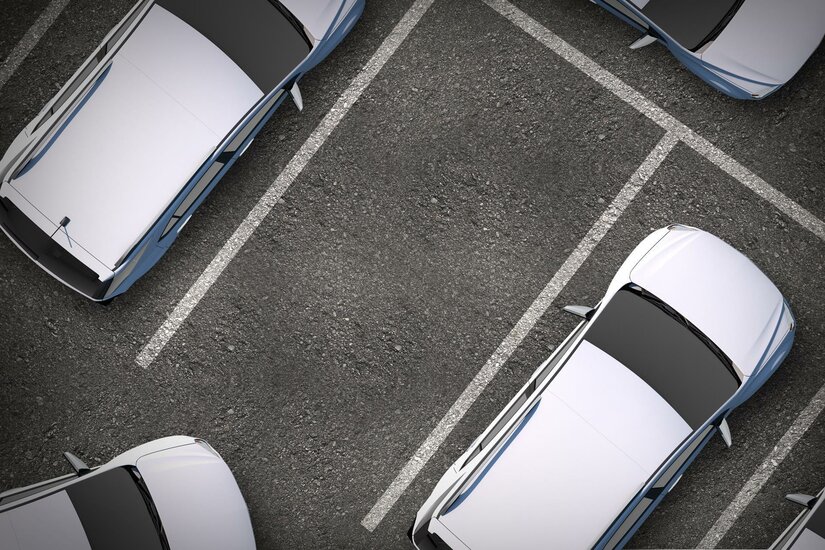 Parkplatz Klosterfeld Draufsicht auf einen asphaltierten Parkplatz mit weißen Markierungslinien und mehreren geparkten Autos.