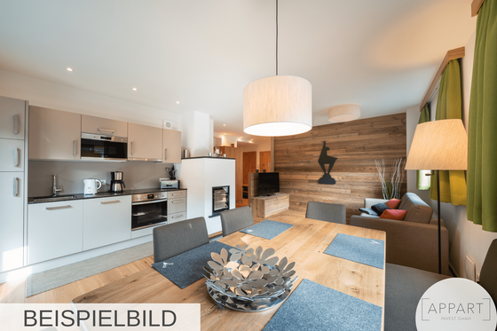 Moderner Wohn- und Essbereich mit Küchenzeile, Holztisch und Sofa vor einer Wand in Holzoptik.