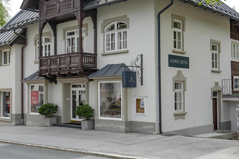 L. Reiter Geschäft Außenansicht des Ludwig Reiter Geschäfts in einem traditionellen Gebäude mit Holzbalkon.