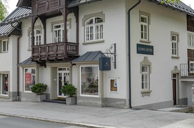 Außenansicht des Ludwig Reiter Geschäfts in einem traditionellen Gebäude mit Holzbalkon.