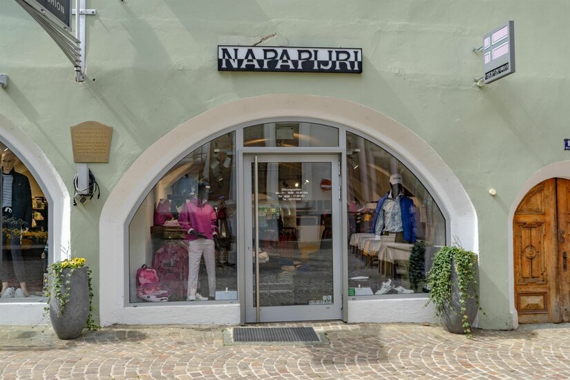Napapijri Store Front Eingangsbereich eines Bekleidungsgeschäfts mit Rundbogenfenster und Schaufensterpuppen.