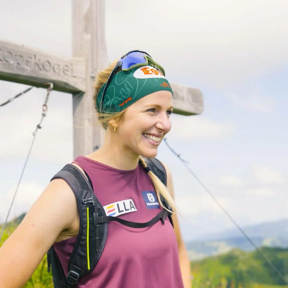 Lisa Hauser vor einem Gipfelkreuz auf dem Berg