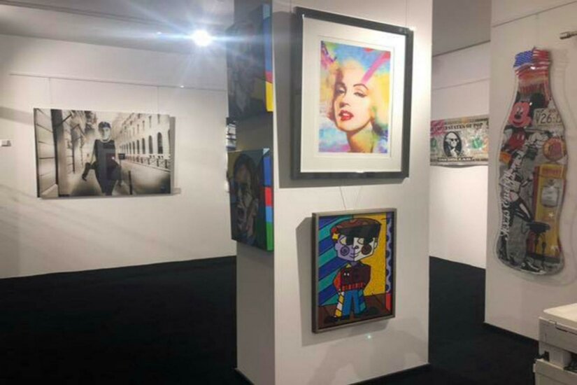 Walentowski Galerie Jochberg Eine Galerie mit verschiedenen Kunstwerken an den Wänden. Zu sehen sind bunte Bilder und Fotografien in einem stilvollen Raum.