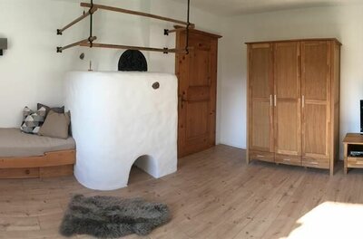 Ein gemütlicher Raum mit einem Holztag, einem Kamin und einem Fernseher. Die Wände sind hell und die Möbel haben einen rustikalen Stil.