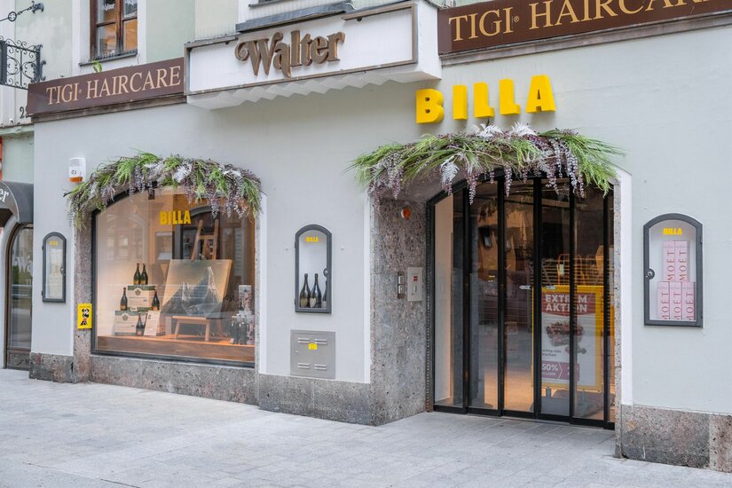 Billa Filiale Vorderstadt Eingangsbereich eines Billa Supermarktes in einem historischen Gebäude mit Blumendekoration über Tür und Schaufenster.