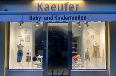 Kaeufer Baby- und Kindermoden Schaufenster des Geschäfts Kaeufer Baby- und Kindermoden mit ausgestellter Kinderkleidung auf Mannequins.