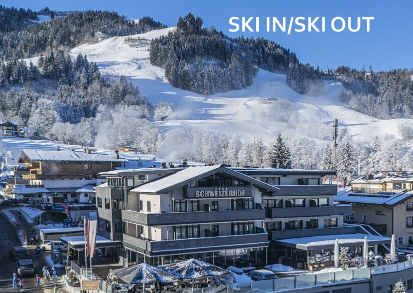 <p>Das moderne Hotel Schweizerhof mit Restaurant in einer verschneiten Berglandschaft. Im Hintergrund ist die Streifabfahrt des Hahnenkamms sichtbar.</p>