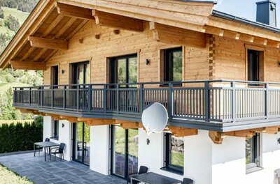 Ferienhaus Reiter in Jochberg Zweistöckiges Ferienhaus aus Holz und weißem Putz mit großem Balkon und Terrasse.