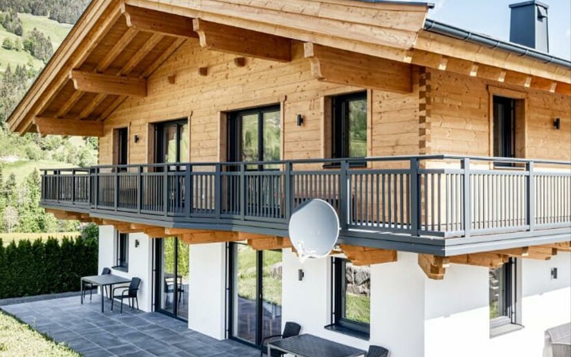 Ferienhaus Reiter in Jochberg Zweistöckiges Ferienhaus aus Holz und weißem Putz mit großem Balkon und Terrasse.