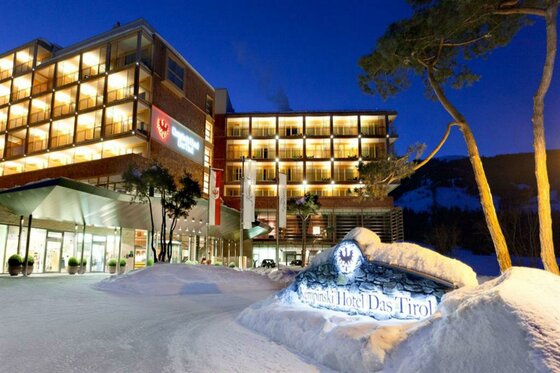 Kempinski Hotel im Winter Beleuchtete Außenansicht des Kempinski Hotels Das Tirol bei Nacht mit verschneiter Einfahrt.