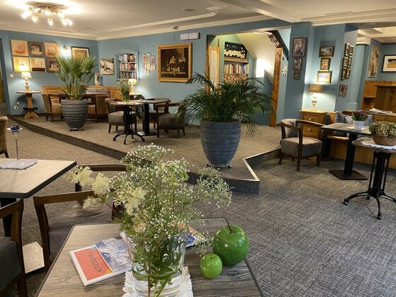 Lounge im Hotel Edelweiss Loungebereich eines Hotels mit blauen Wänden, Sitzgruppen, Zimmerpflanzen und Bildern.