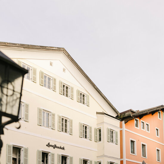 Eine historische Stadtansicht mit bunten Gebäuden und einem nostalgischen Laternenpfahl im Vordergrund.