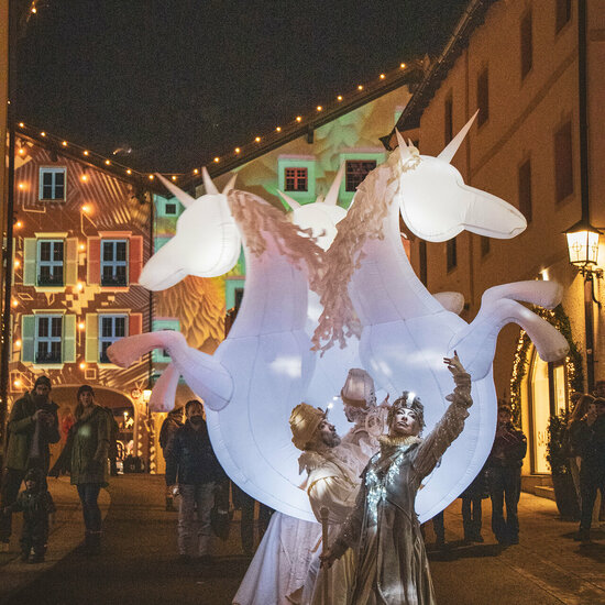 Straßenkünstler mit leuchtendem Einhornkostüm an Neujahr in Kitzbühel