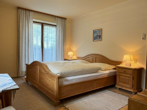 Doppelzimmer Ein gemütliches Schlafzimmer mit einem großen Holzbett und sanfter Beleuchtung.