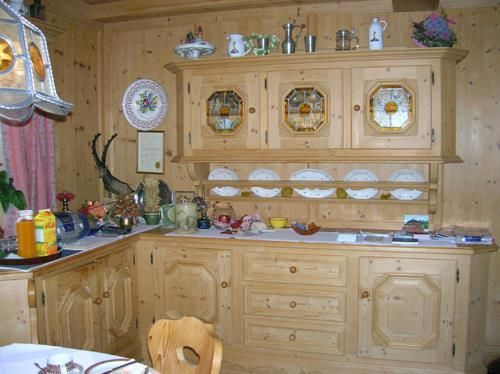 Frühstücksraum im Haus Filzer Rustikales Buffet aus hellem Holz mit dekorativem Geschirr und Glaseinsätzen in einer Stube.