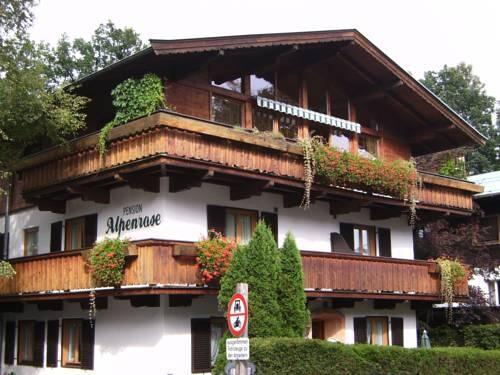 Pension Alpenrose Außenansicht Mehrstöckiges Gebäude mit Holzfassade, Balkonen und Blumenkästen unter einem Satteldach.