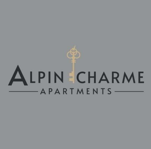 F1966380-8015-4097-9933-8DBFC2C84B55_1_201_a Ein elegantes Logo für die "Alpin Charme Apartments". Es zeigt einen Schlüssel, der Luxus und Gastfreundschaft symbolisiert.